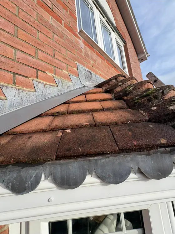 Tiles and flashing where the roof meets a brick wall