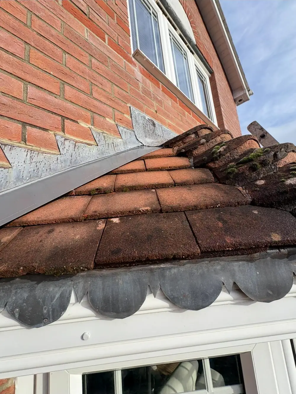 Tiles and flashing where the roof meets a brick wall