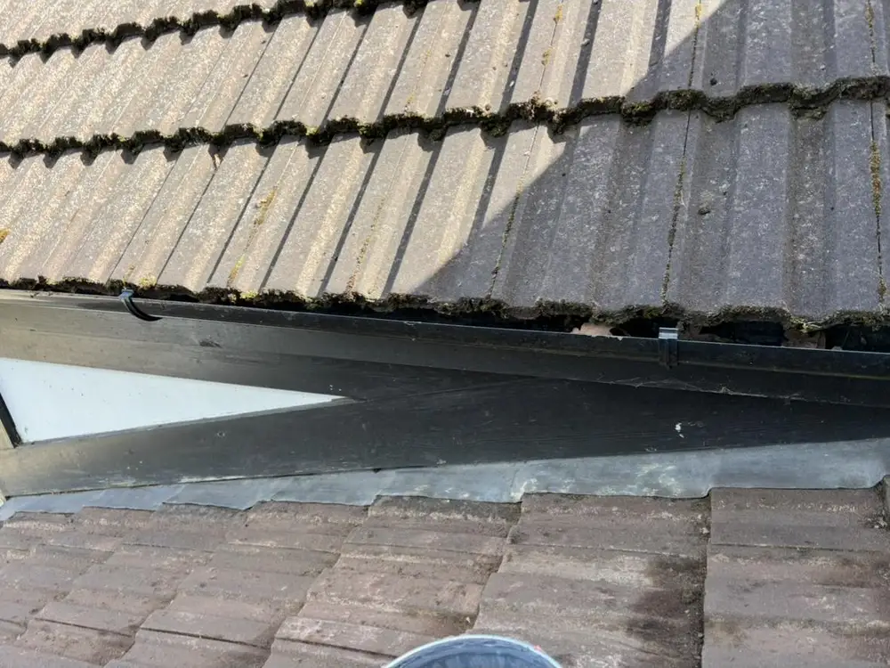 Freshly cleaned roof tiles along a lead-flashed dormer
