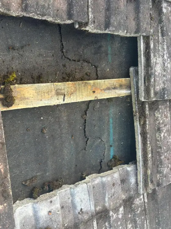Cracked mortar and a valley being repaired on an old roof