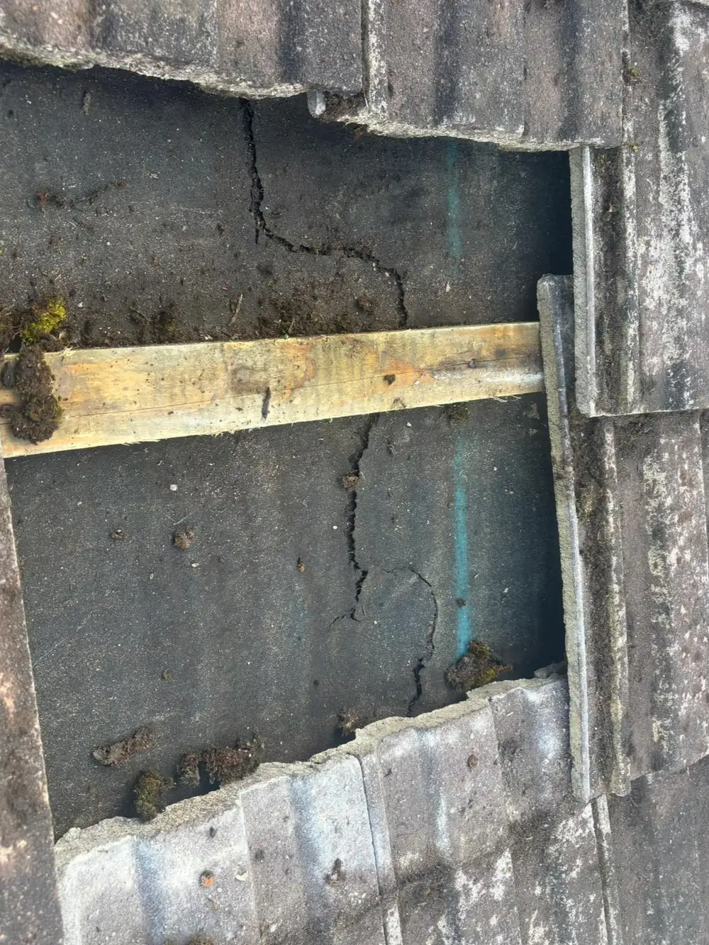 Cracked mortar and a valley being repaired on an old roof