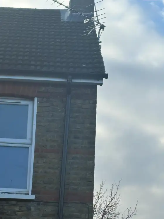 Gable end of a brick house showing the roofline and guttering