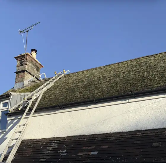 Ladder up to a tiled roof on a two-storey house during roof work