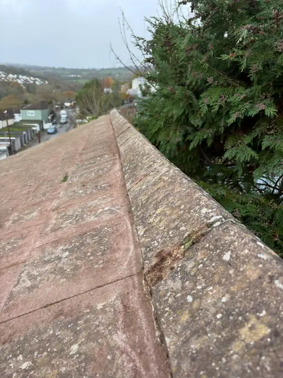 Hip ridge line on a red tiled roof with countryside behind