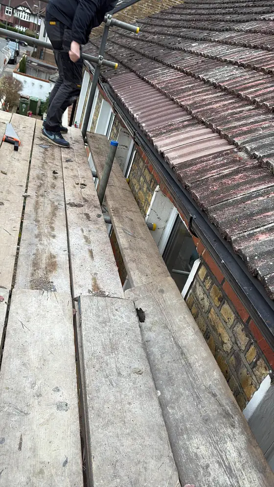 Scaffold walkway running along the eaves of a tiled roof